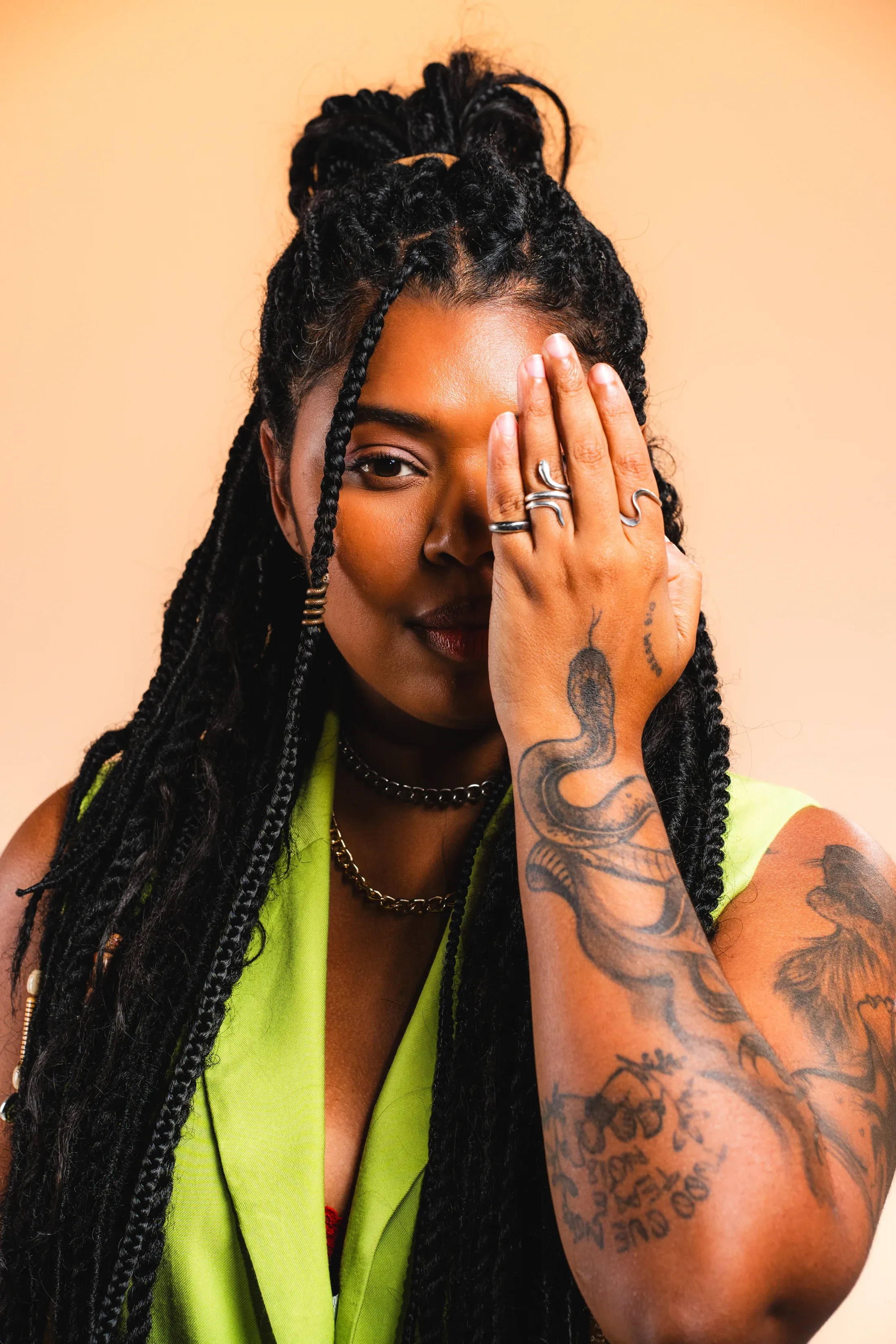 Ágatha Ferreira, com uma das mãos sobre o rosto e roupa verde